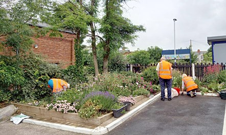 This image shows volunteers tending to flowebeds at one of Northern's stations