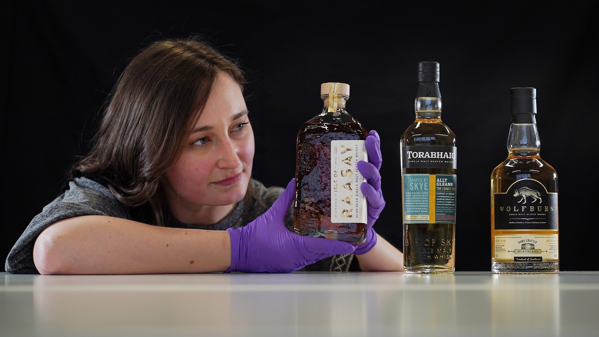 Doctoral Researcher Laura Scobie, with bottles of whisky acquired by National Museums Scotland. Photo © Stewart Attwood WEB