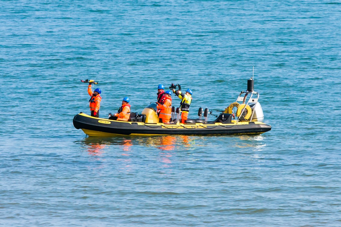 Crew in RIB with UAV 8: Unmanned Aerial Vehicle (UAV) being launched from a Rigid Inflatable Boat (RIB) at Teignmouth as part of a geological survey to improve the resilience of the railway between Exeter and Newton Abbot