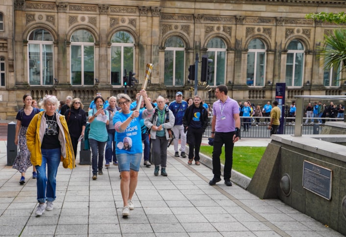 Baton of Hope - Leeds tour 2: Baton bearer Caroline Litman carries the baton through the city centre, followed by supporters, as the Baton of Hope tour comes to Leeds on World Suicide Prevention Day.