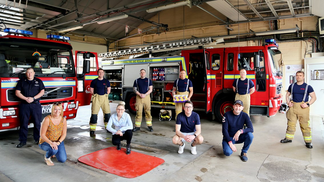 Railway manager helps organise lock-down give-away of 1,000 Easter eggs: Network Rail's Chris Williamson (BOTTOM RIGHT) with firefighters at Whitehaven fire station before Easter egg giveaway