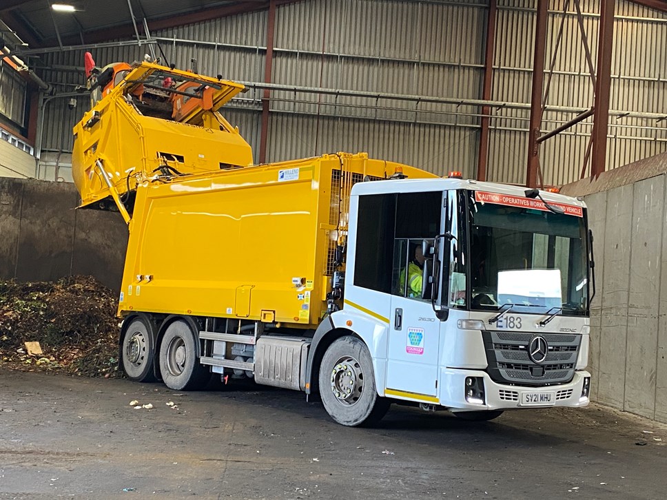 A yellow and white Moray Council refuse vehicle is offloading garden waste at the Waste Treatment Plant, Moycroft Road, Elgin.