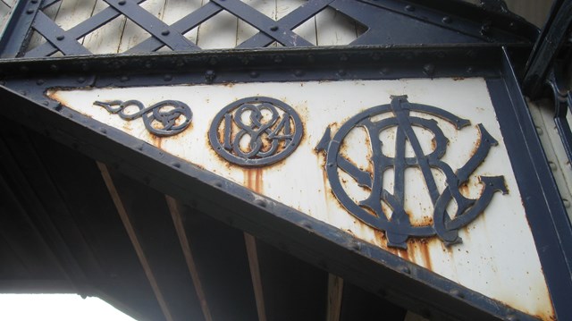 Hagley station footbridge before restoration: Detail showing GWR logo and date