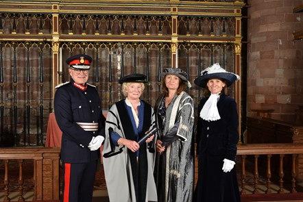Four dignitaries dressed in formal uniforms and academic clothes