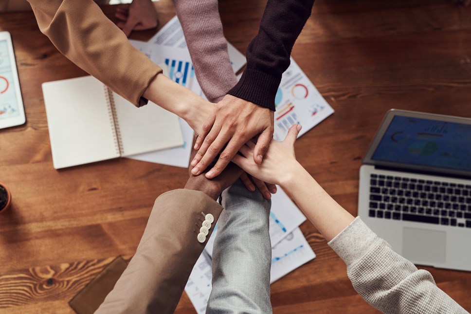 people's hands over a work desk