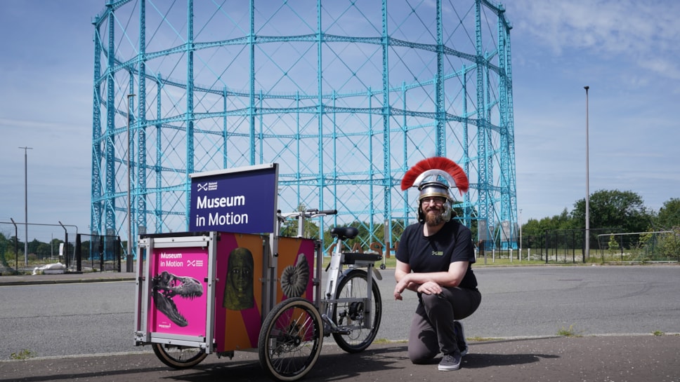 Enabler David Cree kneels beside National Museums Scotland's new cargo bike, Museum in Motion.