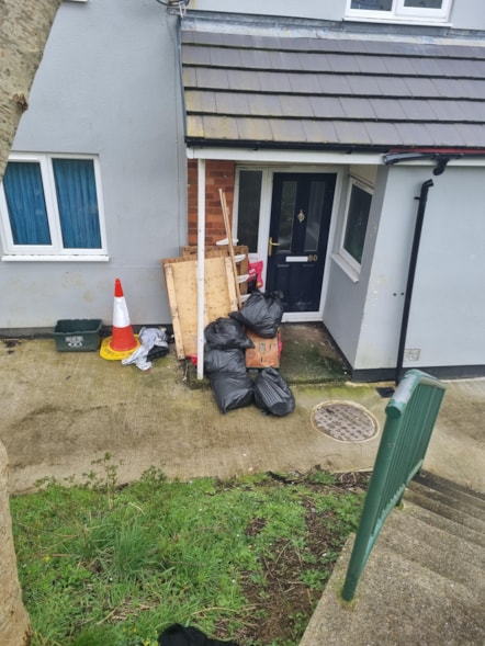 Black bags and other rubbish outside house