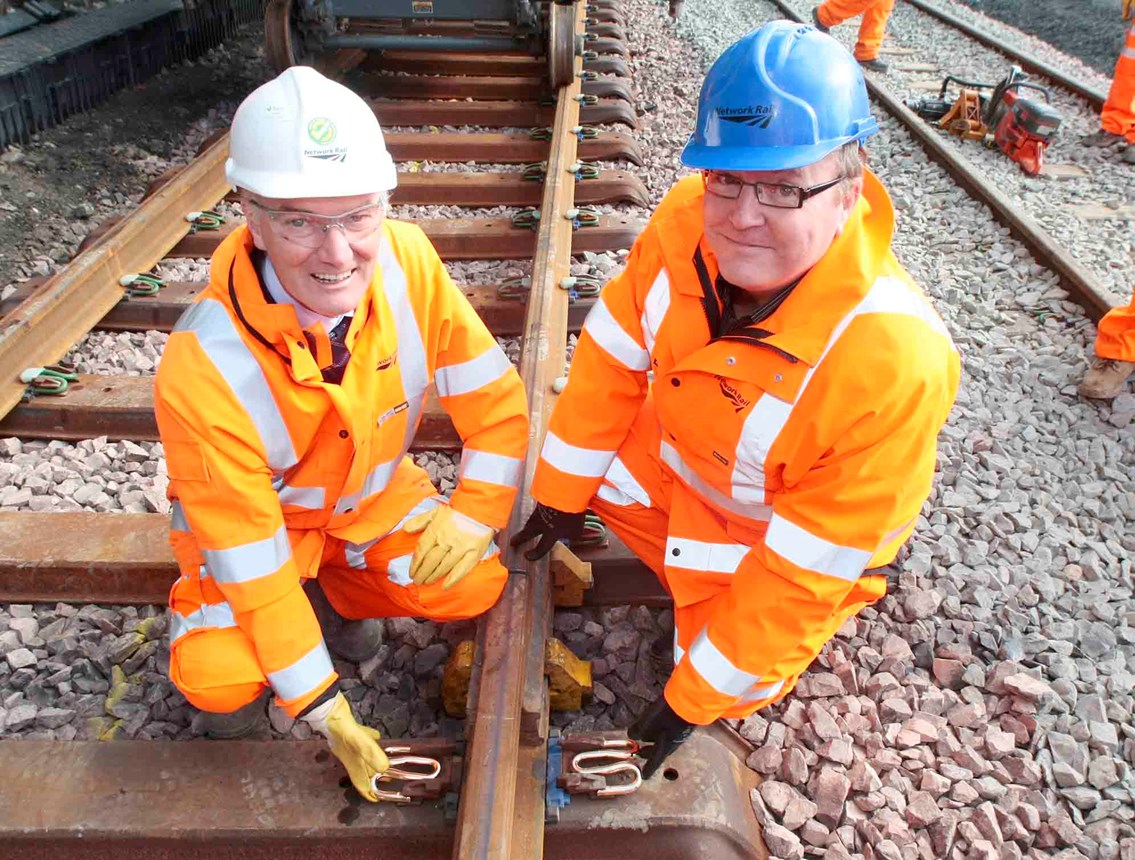 FINAL TRACKS LAID ON AIRDRIE-BATHGATE RAIL LINK_1: Hugh Wark, Senior Project Manager (left) and Alan Macmillan, Scheme Sponsor (right) install the final 'golden' pandral clip on the Airdrie-Bathgate line this morning (27 Aug). The 15 miles of new track now link passenger branch lines to Airdrie and Bathgate for the first time in more than fifty years.