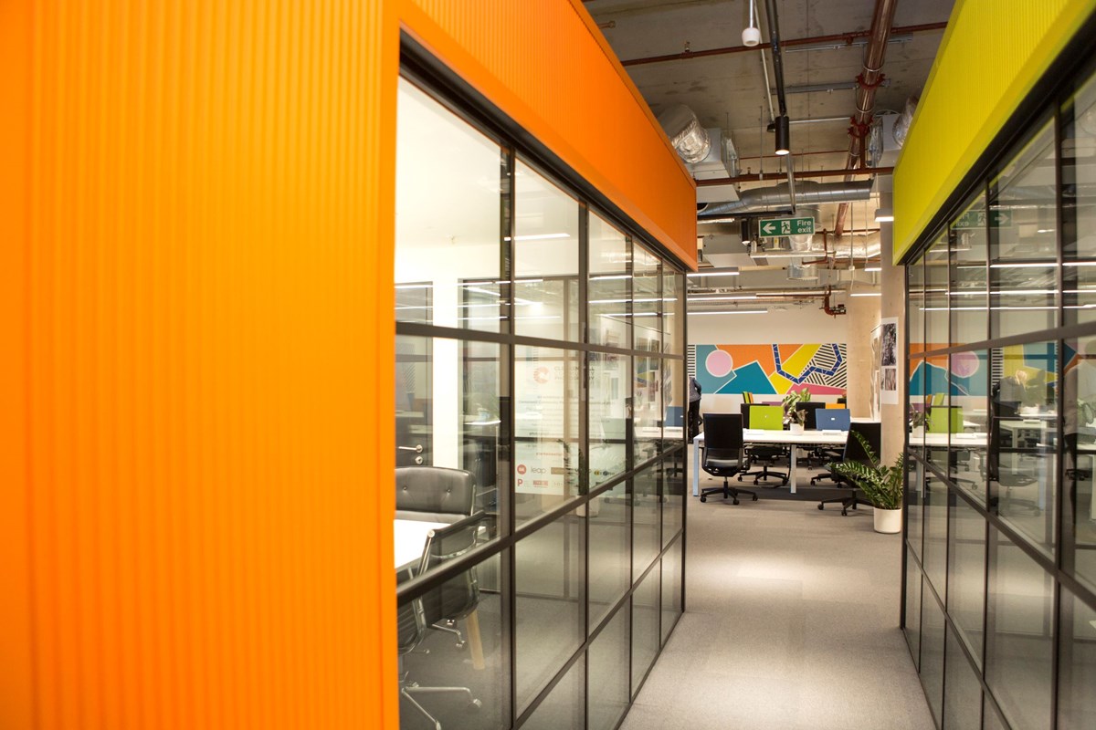 Brightly coloured corridor and desks in Islington's Better Space affordable workspace, created by Islington Council in partnership with City, University of London