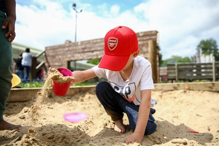 A child plays in the sand pit in Islington's Lumpy Hill Advenuture Playground