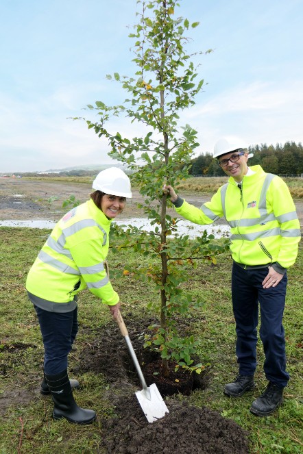 County Councillor Phillippa Williamson (left) prepares to plant the tree, which is being held by County Councillor Aidy Riggott (right).