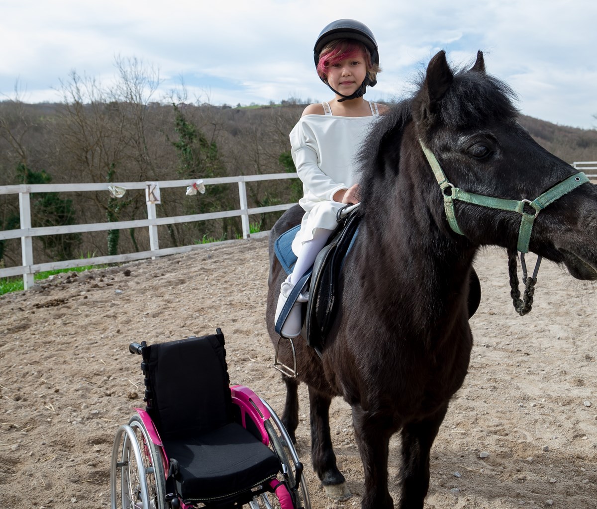 Disabled child riding horse