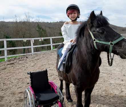 Disabled child riding horse