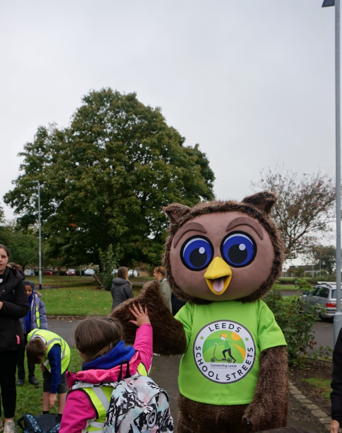 Arlo the Owl, the council's safe and sustainable travel mascot giving a high five to a pupil from Ireland Wood Primary School: Image shows Arlo the Owl, safe and sustainable travel mascot giving a high five to a pupil from Ireland Wood Primary School