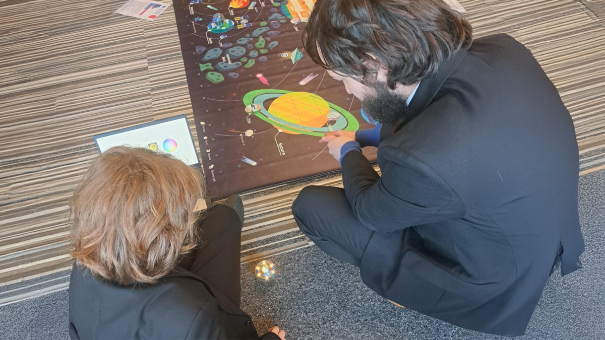 Cllr Salter and a pupil from Carnforth High School discuss how to remotely move the SPHERO Bolt robot at the Lancaster and Morecambe MEGA Hub.