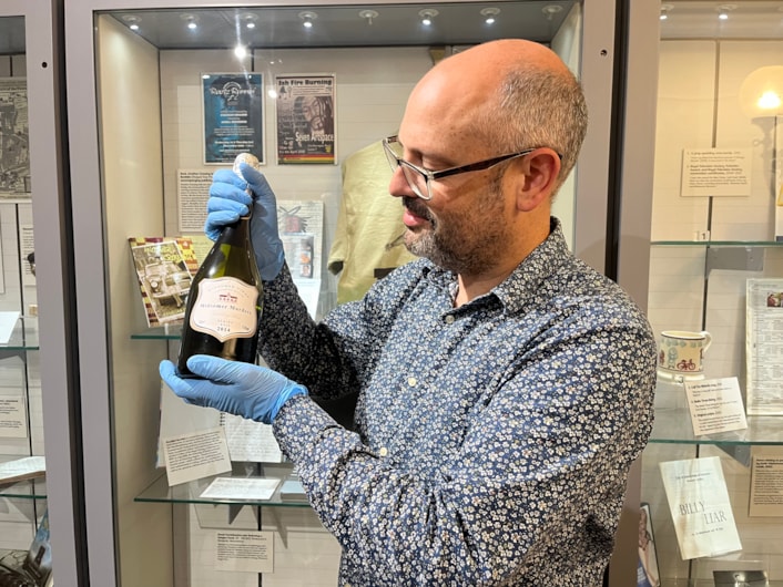 Literature in Leeds: Curator Patrick Bourne with a wine bottle from the set of celebrated bucolic British crime drama Midsomer Murders, on loan from screenwriter and playwright Lisa Holdsworth who has also worked on hit shows including Call the Midwife and Fat Friends.
