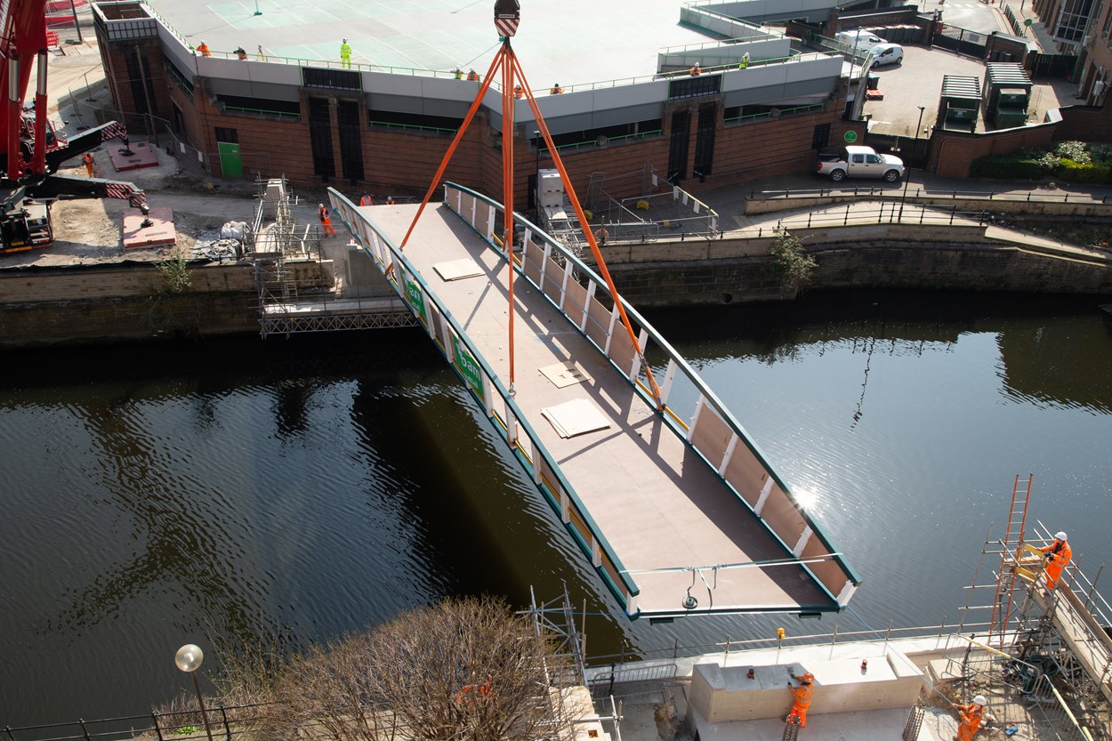 David Oluwale bridge installation: The David Oluwale bridge is lifted into place over the River Aire in Leeds. Engineers working on the David Oluwale bridge completed one of the project’s major milestones over the weekend, with cranes carefully placing the 40 tonne structure over the river where it will connect Sovereign Street to Water Lane. Credit BAM Nuttall.