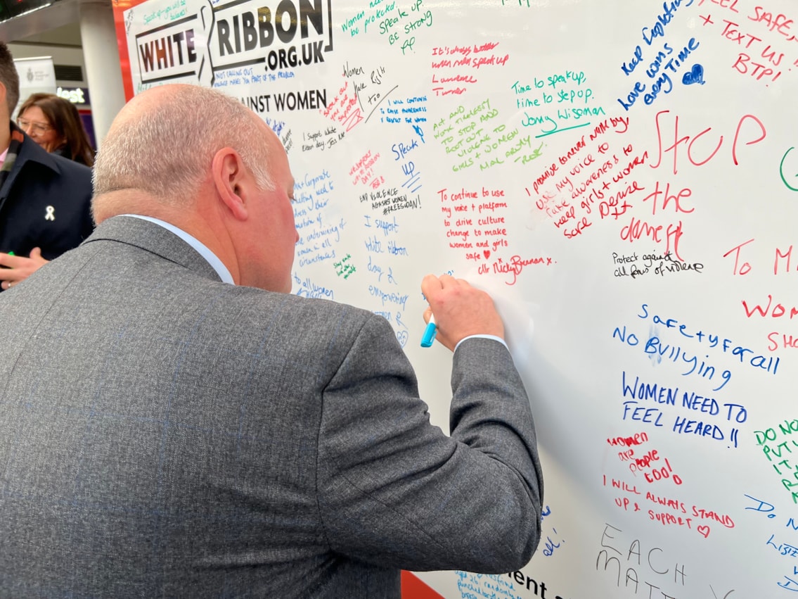 Andy Mellors, managing director for Avanti West Coast, signing the White Ribbon pledge wall
