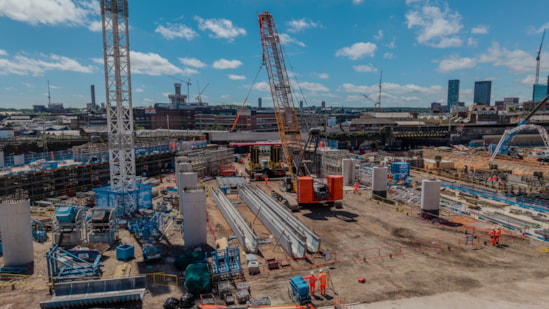 Crawler crane lifting a U-beam on the site of what will become a tram stop for the Midlands Metro June 2026