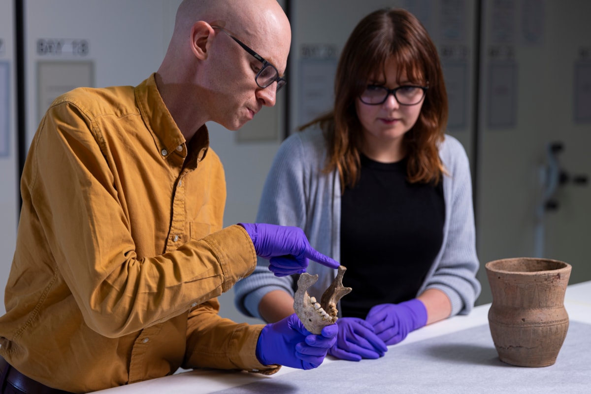 National Museums Scotland curators Dr Matthew Knight and Bethany Simpson examine archaeological human remains. Photo © Duncan McGlynn