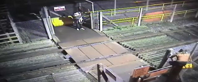 Woman climbs over locked level crossing gate