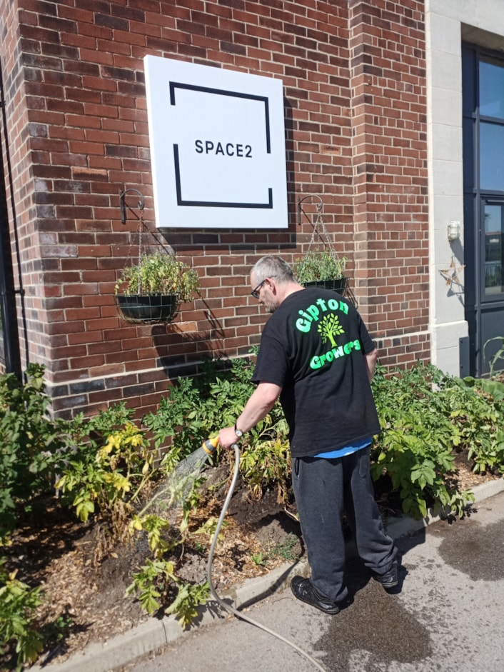 DPHAR 2026 - Gipton Growers: A member of the Space2's Gipton Growers watering the plants at their community garden at the Old Fire Station community hub.