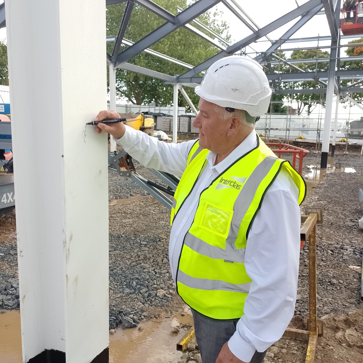 Councillor Patrick Harley, leader of Dudley Council signs a girder