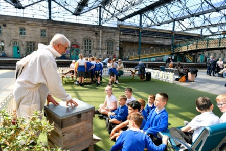 Beekeeper, Harold Bowron, gives pupils from Robert Ferguson Primary School an insight into a beehive for World Bee Day