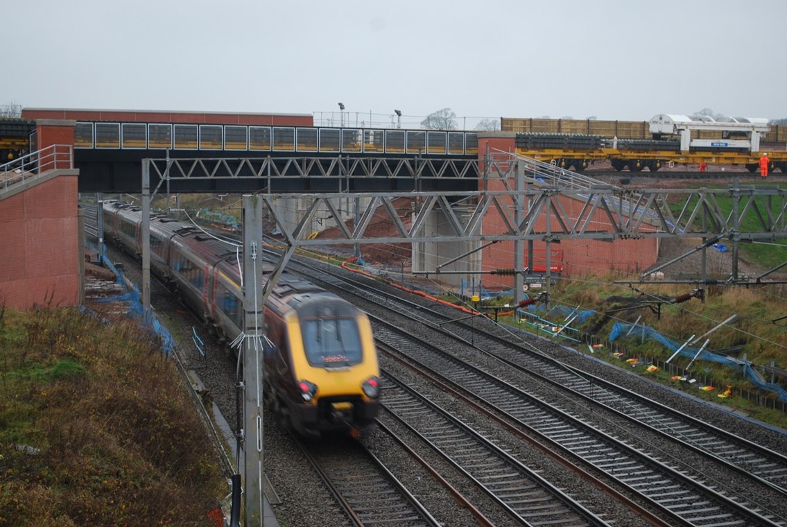 NTC (track-laying) train passes over existing WCML at Norton Bridge on new flyover (XC Voyager beneath)