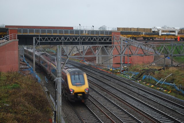 Stafford railway upgrade scheme sets track-laying record: NTC (track-laying) train passes over existing WCML at Norton Bridge on new flyover (XC Voyager beneath)