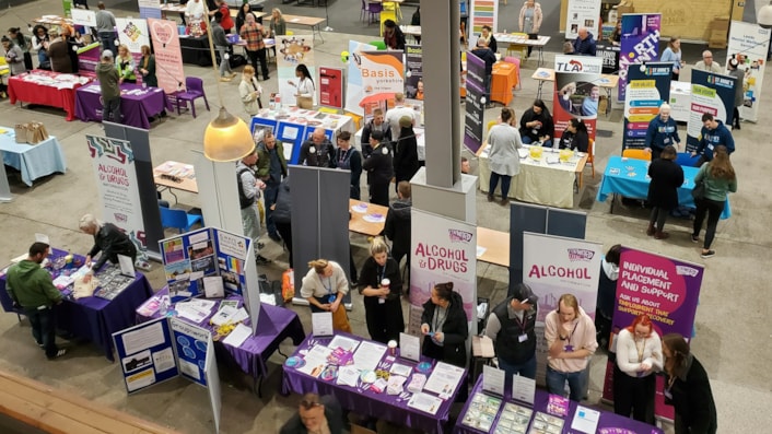 Kirkgate Market event: Image shows a high view over the indoor market which is filled with table and stalls covered with information from various organisations.