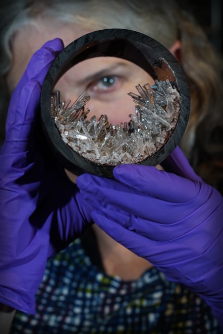 Dr Rachel Walcott, Principal Curator of Earth Systems, with a plastic pipe containing gypsum crystals, image copyright Stewart Attwood