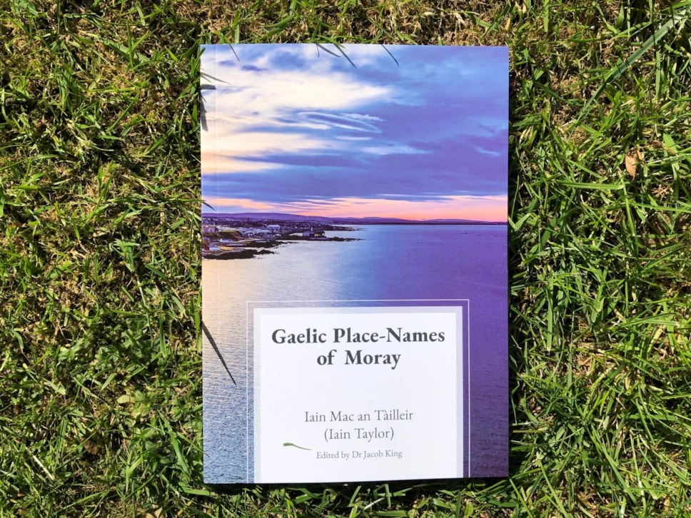 A photo of the book Gaelic place-names of Moray, on a bed of grass. The author is Iain Taylor, and it is edited by Dr Jacob King.