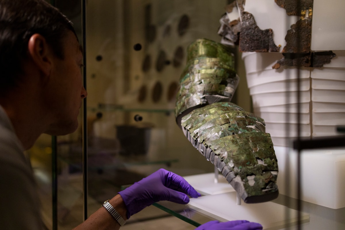 Dr Fraser Hunter installs the Roman arm guard in the Early People gallery at the National Museum of Scoltand. Image copyright Duncan McGlynn (7)