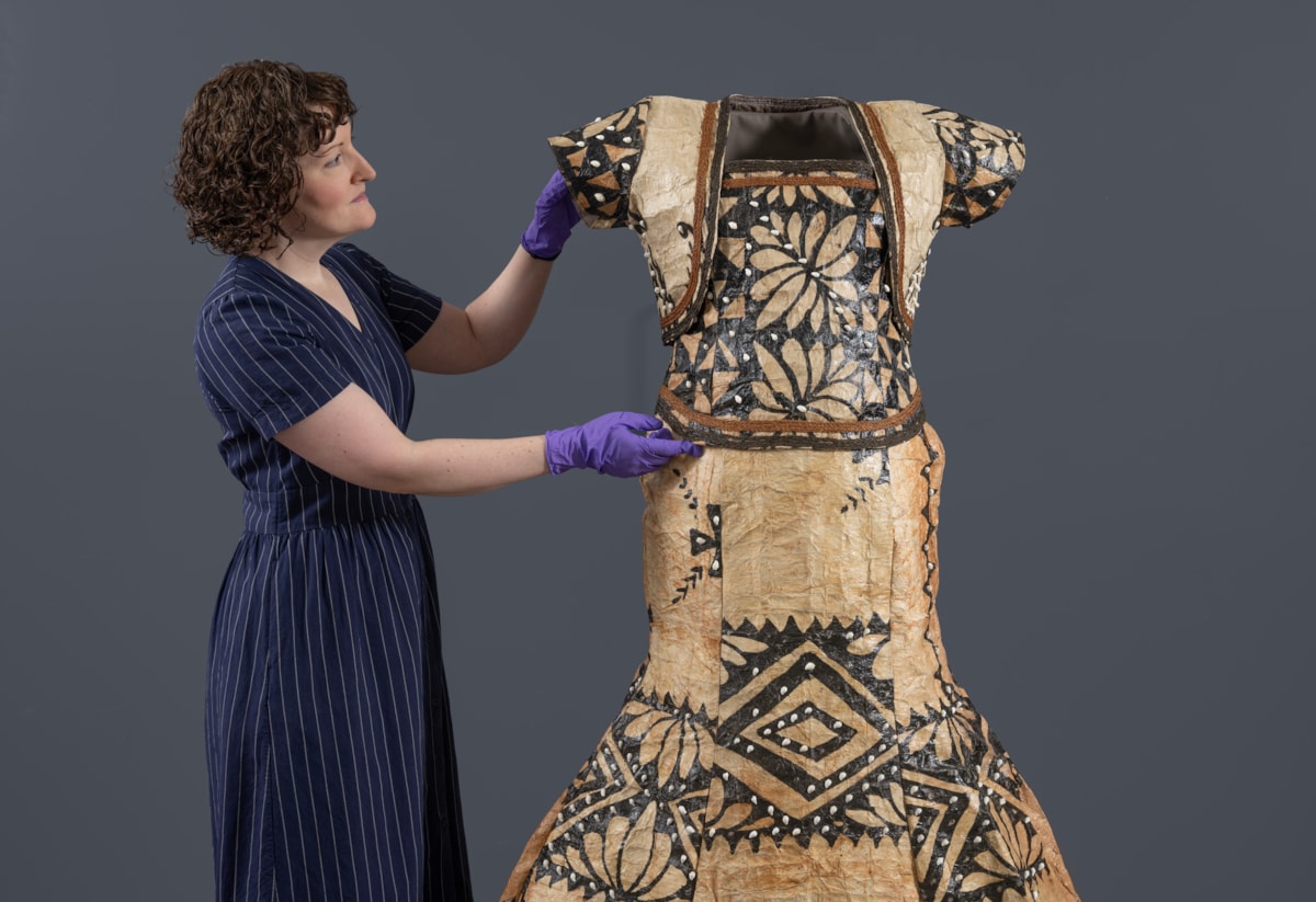 Curator Ali Clark prepares the barkcloth wedding dress for display. Photo © Neil Hanna (3)
