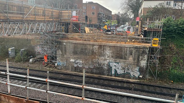 Engineers preparing to lift in the new bridge across the railway. The temporary structure carrying electricity connections can be seen to the left: Engineers preparing to lift in the new bridge across the railway. The temporary structure carrying electricity connections can be seen to the left