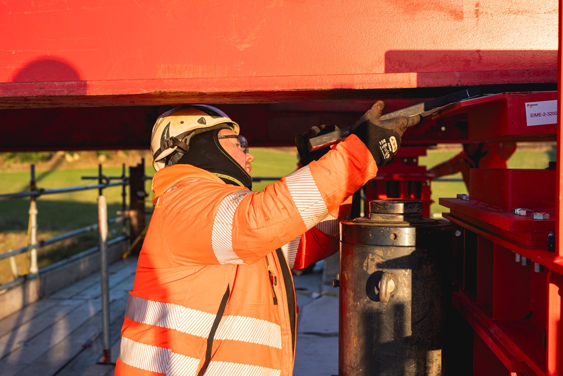 Specialist engineer from Eiffage Metal feeding a teflon pad into position during the Wendover Dean deck slide 10.01.24