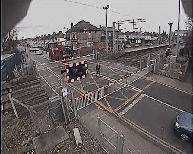 Reckless pedestrian strolls across Enfield Lock crossing: A pedestrian recklessly risks his life at Enfield Lock level crossing, squeezing between both sets of closed barriers.