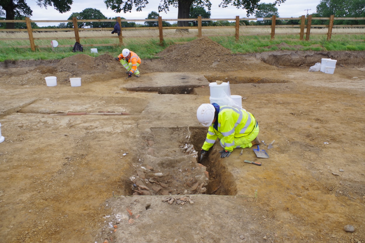 ELOR archive: Archaeologists excavate a drainage ditch with backfill of discarded late 18th to 19th century ‘rubbish’ items like broken pieces of ceramic or porcelain, animal bone, oyster shell, glass and fragments of building material. Credit Wessex Archaeology.