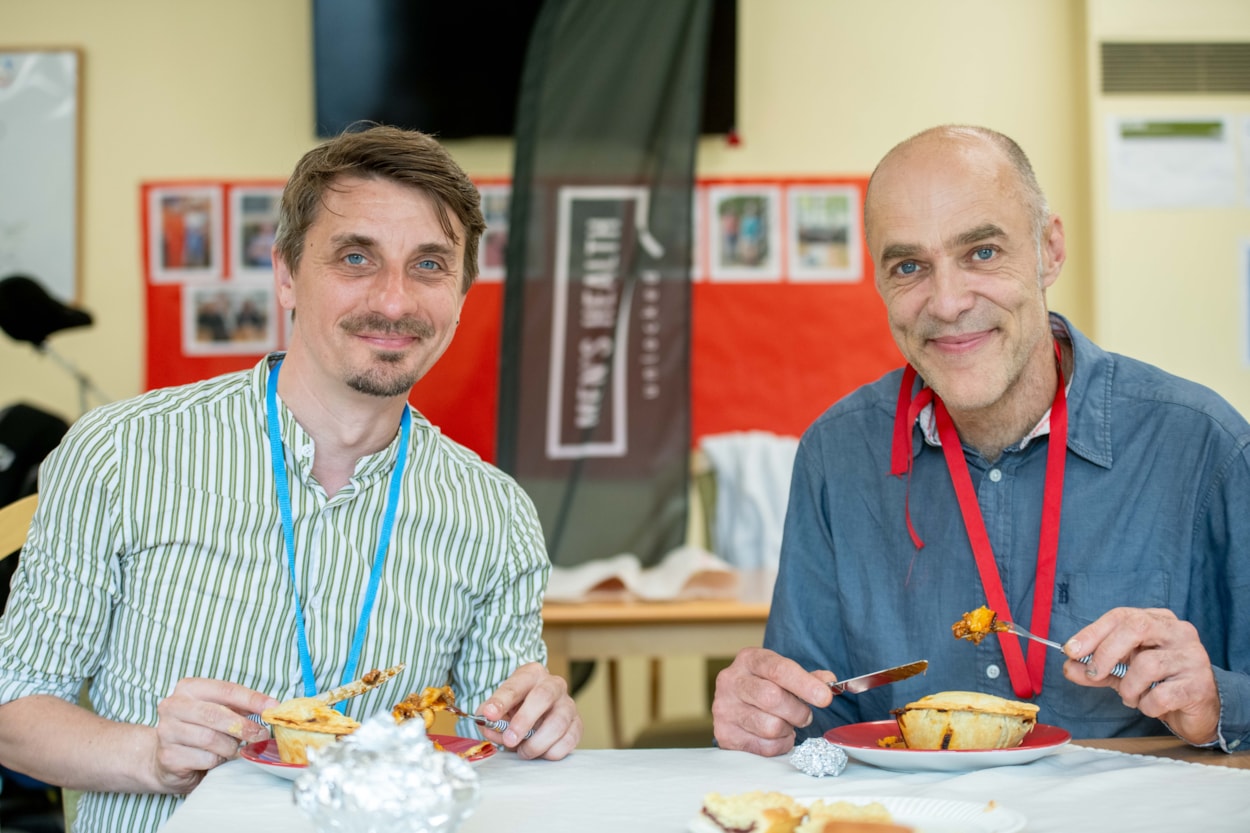 Men's Health 1: Councillor Paul Wray, Leeds City Council's leader member for men's health, left, with Damian Dawtry, project manager at Men's Health Unlocked, pictured tucking into pies at a Wykebeck Pie Club event in June. The pie club is a national initiative bringing men together to make and eat pies and socialise. Picture: Mark Bickerdike
