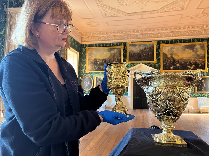 Temple Newsam treasures: Leeds Museums and Galleries conservator Emma Bowron with a silver gilt cup made by John Fig in 1842 and the silver gilt Doncaster Gold Cup 1828-29, part of an array of silverware that has been conserved for a revamped display at Temple Newsam House.