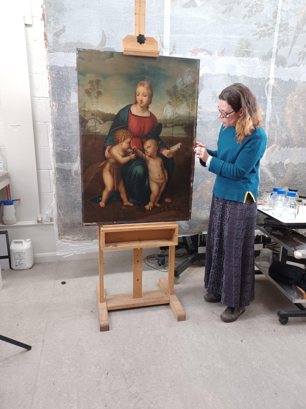 Painting conservator with unframed painting