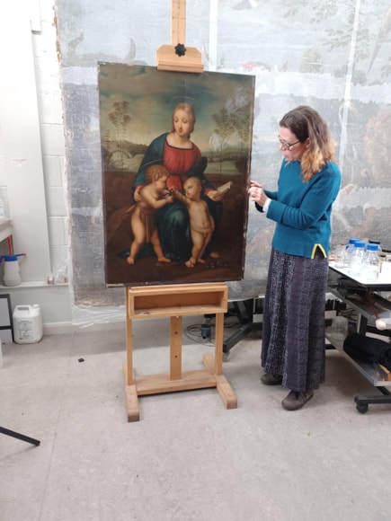 Painting conservator with unframed painting
