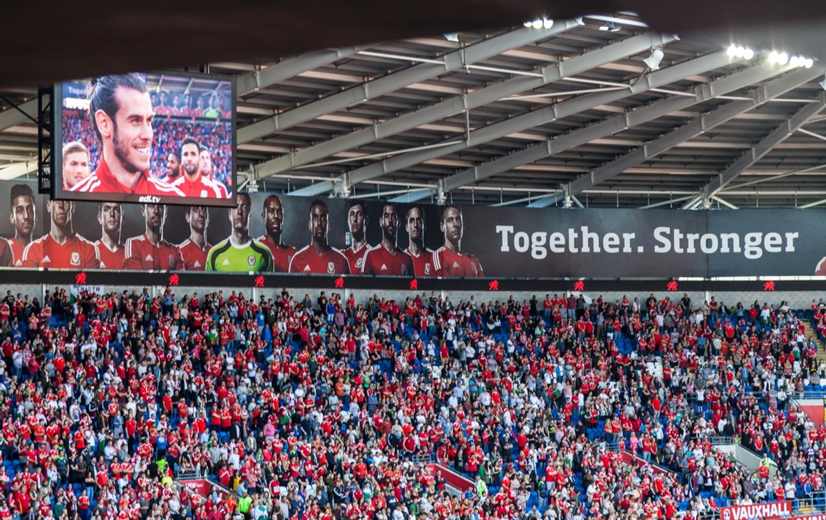 Wales fans red wall with Together Stronger slogan in stadium