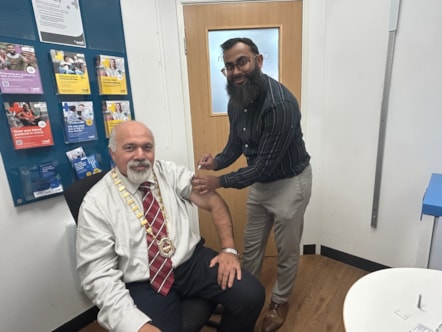Deputy Mayor Councillor Mushtaq Hussain recives his vaccine at Well Pharmacy at The Northway from pharmacist Thanvir Choudhury