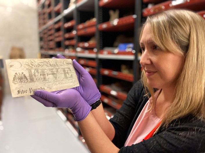Money Talks: Kat Baxter, Leeds Museums and Galleries’ curator of archaeology and numismatics with one of the local bank notes carrying the branding of both the city itself and now defunct local banking institutions like The Leeds Bank, Leeds Union Bank and Leeds Commercial Bank.