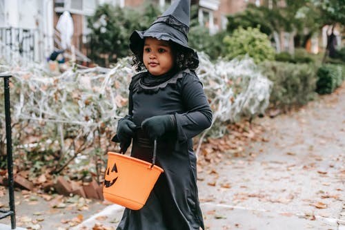 little girl in witch costume credit charles parker pexels