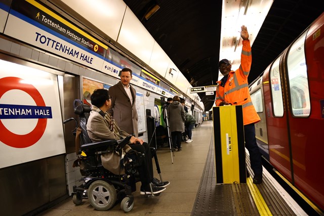 Seb Dance, Deputy Mayor for Transport in London and James Lee from TfL's Independent Disability Advisory Group wait to see a new mini ramp being used at Tottenham Hale station